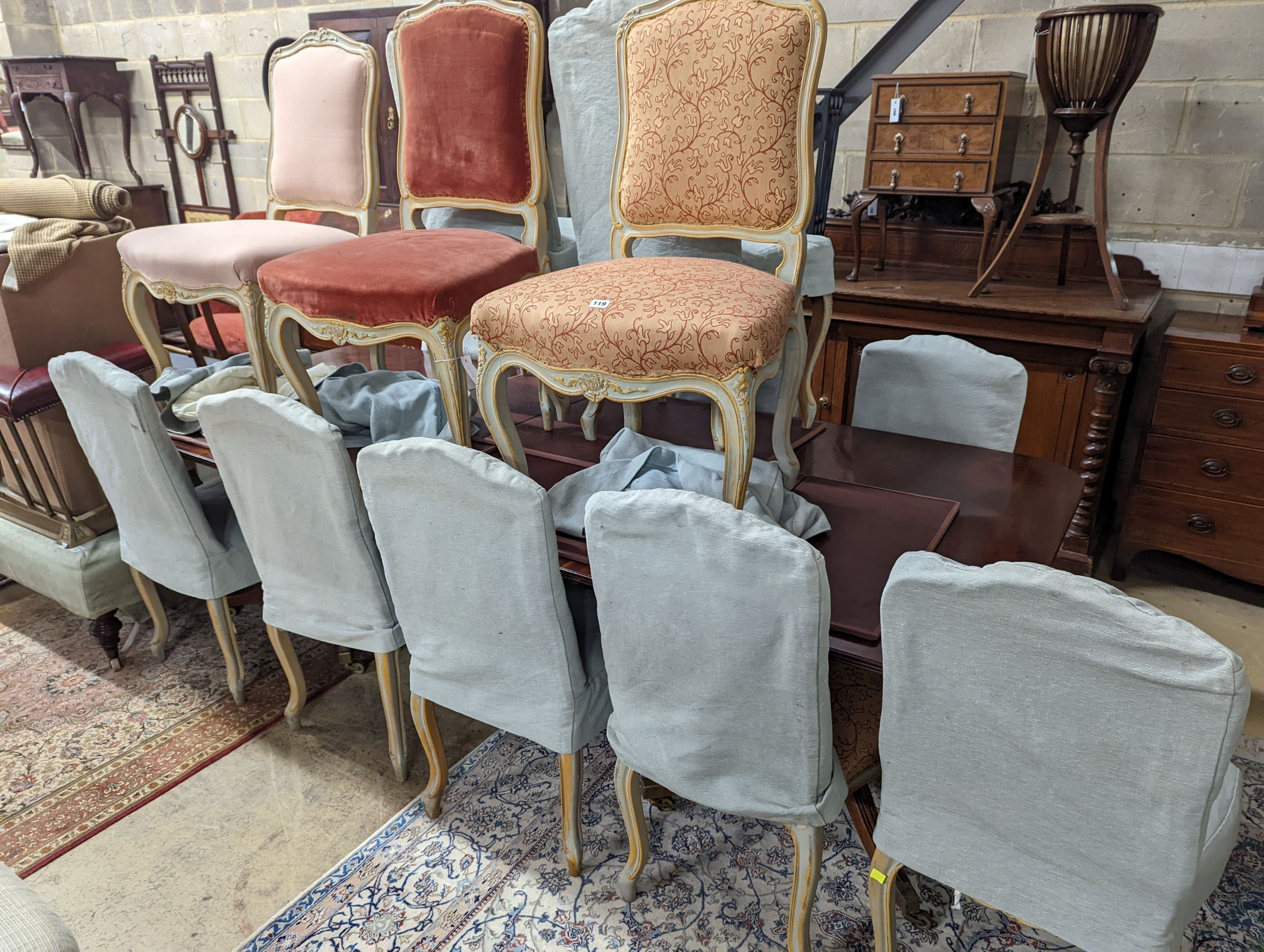 A set of fourteen French Louis XV style painted upholstered dining chairs with loose covers